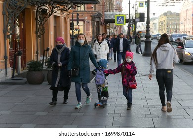 Saint-petersburg, Russia - 7 April 2020: A Mother With Two Children In Masks Walk Along A Busy Sidewalk On Nevsky Prospekt