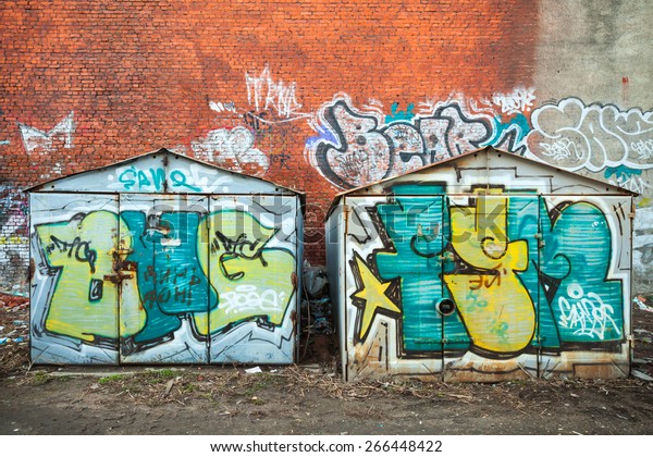 Saint-Petersburg, Russia - April 3, 2015: Old rusted\
garages with colorful grungy graffiti. Vasilievsky island, Central\
old part of St. Petersburg\
city