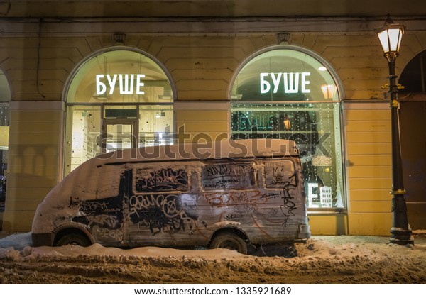 SAINT-PETERSBURG, RUSSIA – JANUARY
11, 2019: Cars parked in snow drifts on a winter night in the
center of St. Petersburg against the background of historic
buildings.