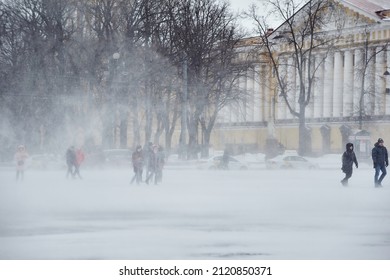 SAINT-PETERSBURG, RUSSIA - MARCH 09 2019: People Walk In A Strong Snow Blizzard In A Very Cold And Snowy Spring Day  Around  The Square, Struggling With Wind