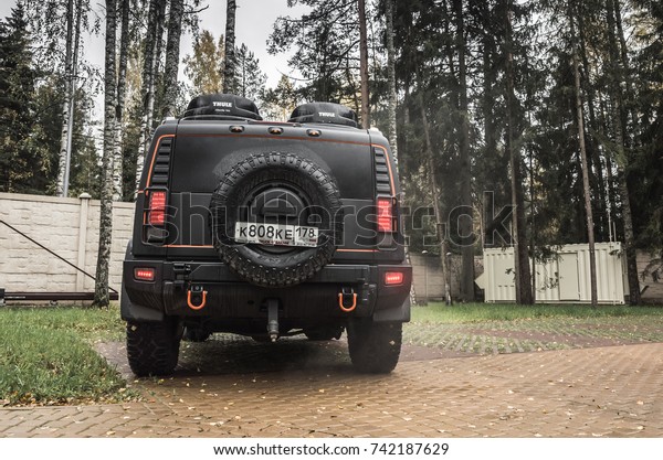 Saint-Petersburg, Russia - October 8, 2017: Black\
Hummer H2 car stands on rural parking lot in Russian countryside,\
back side