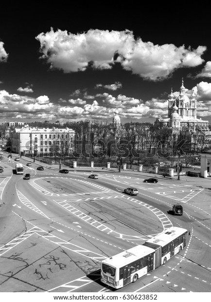 Saint-Petersburg. Russia. View\
from high point at the road with buses and cars. Orthodox church\
cathedral.Square. Center of the city. Clouds in the sky.Black and\
white image.
