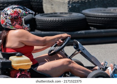 Saint-Zotique, Canada - June 25, 2022: An Adult Woman Wearing A Helmet Races Around An Outdoor Go Kart Track 