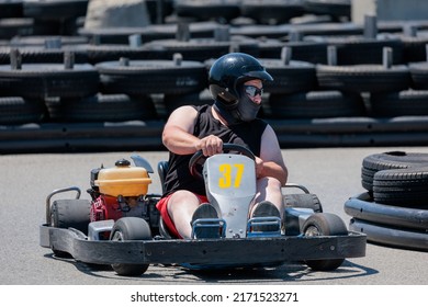 Saint-Zotique, Canada - June 25, 2022: A Masked Adult Man Wearing A Helmet Races Around An Outdoor Go Kart Track 