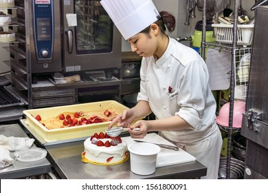 Sakaiminato, Japan - September 27th, 2019: A Japanese Female Pastry Chef Decorating A Cake With Powdered Sugar.