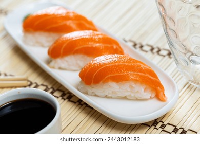 Sake nigiri sushi with salmon served on platter with soy sauce - Powered by Shutterstock