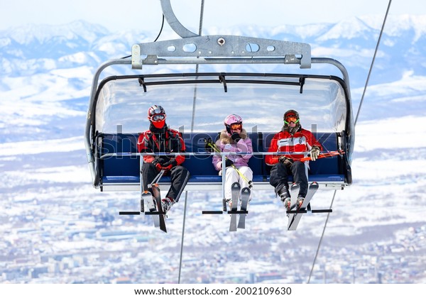 Sakhalin, Russia - March 26, 2011: Ski elevator\
lifts skiers to the hill against the snow-covered mountains in the\
Sakhalin Island.