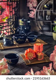Sakura mooncakes with chienese tea set on the table. A mooncake is a Chinese bakery product traditionally eaten during the Mid-Autumn Festival. - Shutterstock ID 2195163663