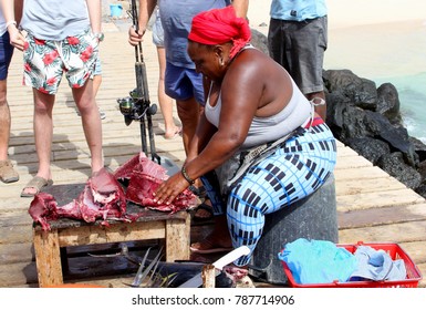 SAL, CAPE VERDE, AFRICA - December 20, 2017. Portrait Of African Sales Women Cutting Fresh Caught Tuna Fish And People Buying Sea Food At Local Street Market On Pier In Ocean. Barlavento Archipelago. 