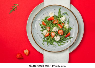 Salad With Arugula, Strawberries, Ricotta And Chia Seeds. Overhead, On A Bright Red Background, A Copy Of The Space