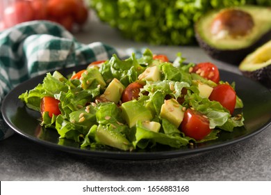 Salad with avocado, lettuce, tomato and flax seeds on gray background.Close up - Powered by Shutterstock