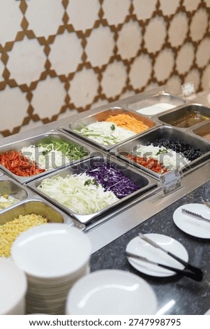 Salad bar offers an array of vibrant fresh vegetables alongside various dressings for a healthy and customizable meal experience