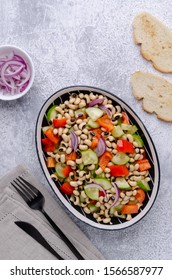 Salad with beans and fresh vegetables in a dish on a slate background. Selective focus.
