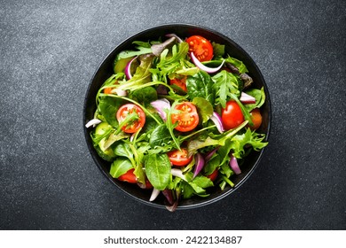 Salad in black bowl at dark background. Healthy green vegetable salad, diet menu. Top view. - Powered by Shutterstock