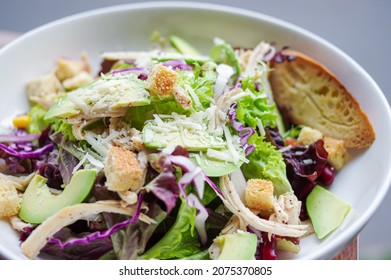 Salad With Bread, Avocado, Lettuce, Shredded Cheese And Sliced Chicken Breast In White Bowl Top View