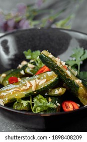 Salad of broken cucumbers with sesame seeds, sugar, red and black pepper, olive oil.