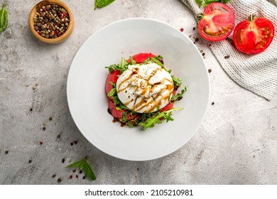 Salad With Buratta Cheese And Tomatoes On Plate On Grey Concrete Table Top View