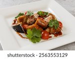 Salad with crispy fried eggplant, tomatoes and cilantro in sweet chili sauce. Sweet chili crispy battered eggplants salad, crispy deep-fried eggplant