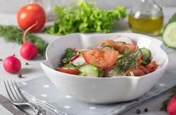 Salad With Cucumbers, Tomatoes And Radishes Dressed With Olive Oil In White Salad Bowl On A Gray Background