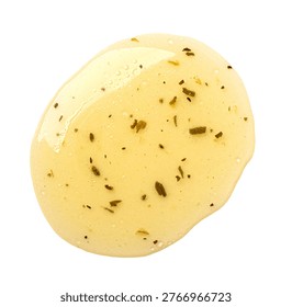 Salad dressing with herbs dropping, creating a textured yellow splash on white