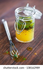 Salad Dressing With Olive Oil; Orange Juice; Chili And Herbs In A Glass Jar; Selective Focus