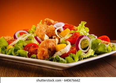 Salad With Fried Chicken Strips On Wooden Table 