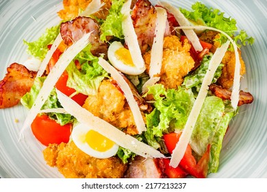 Salad With Fried Chiken And Bacon On A Black Background