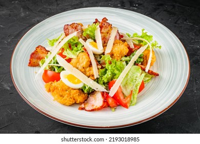 Salad With Fried Chiken And Bacon On A Black Background