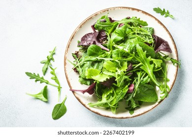 Salad from green leaves and vegetables on white. - Powered by Shutterstock