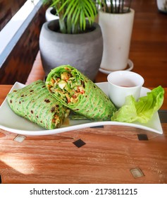 Salad green wraps with ingredients above. Sweet corn, avocado, green paprika, sprouts, mushrooms and prawn on wood board background.