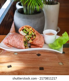 Salad green wraps with ingredients above. Sweet corn, avocado, green paprika, sprouts, mushrooms and prawn on wood board background.