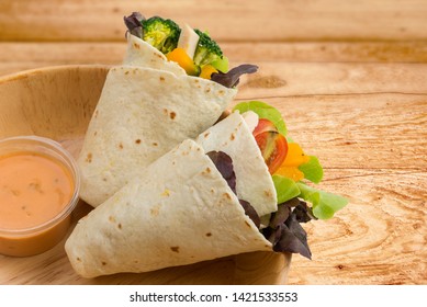 Salad Kebab, Pita bread, Tortilla wrap with mixed vegetable, in wooden bowl, healthy meal for grab & go food, with salad sauce thousand island dressing, spoon ready to eat on isolated white background