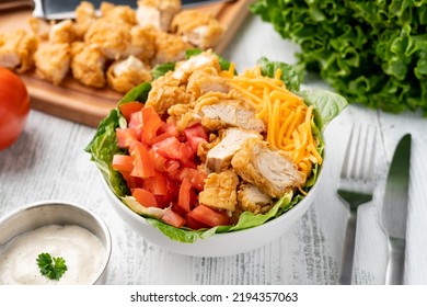 Salad Made With Fried Chicken Tender Cubes, Tomato, Cheese, Lettuce And Ranch Dressing.