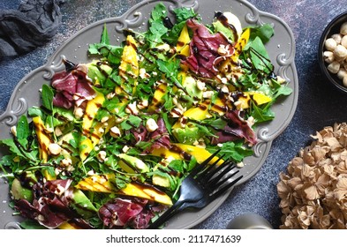 Salad with mango, avocado, arugula and jamon