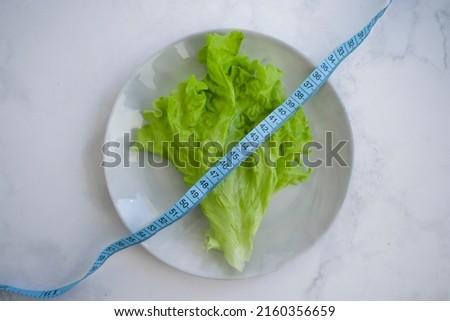 Similar – Image, Stock Photo Fresh leaf salad with a measuring tape on a board