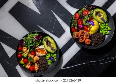 Salad With Olives, Salmon, Chia, Tomatoes, Arugula, Sesame Seeds, Endive, Mozzarella, Avocado, Beans, Violet Flower In A Plate And Other Salad With Tomatoes, Chia, Shrimp, Broccoli, Arugula, Sesame Se