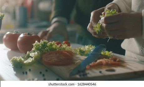 Salad Preparation Process. Woman Preparing Salad At The Kitchen Table. Proper Nutrition And Wellness. Process Of Mixing Fresh Salad. Eating At Home. Food Industry. Shot On Arri Alexa Mini Cinema