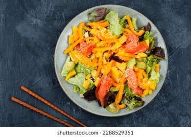 Salad with smoked salmon, mango, sesame and avocado on a dark background. Top view - Powered by Shutterstock