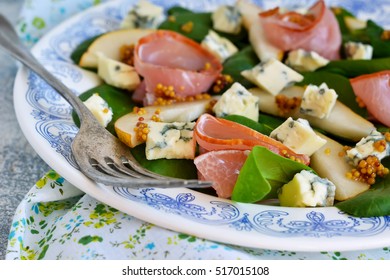 Salad With Spinach, Blue Cheese, Ham And Pear Sauce On A Concrete Background