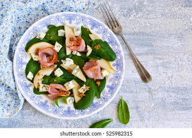 Salad With Spinach, Blue Cheese, Ham And Pear Sauce On A Concrete Background