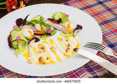 Salad of stewed meat, green, perepilinyh poached eggs, cucumbers, basil, plum and Dutch sauce with walnuts. Wooden background. Close-up