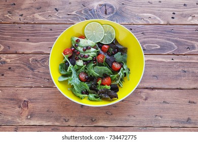 Salad with tomato, baby lettuce, in yellow bowl - Shutterstock ID 734472775