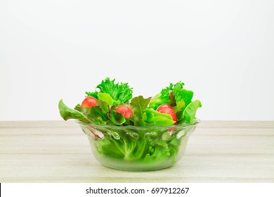 Salad Vegetables In Glass Bowl On Wooden Table On White Background Side View, Healthy Lifestyle Concept