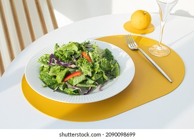 Salad With Yellow Leather Table Mat On White Table