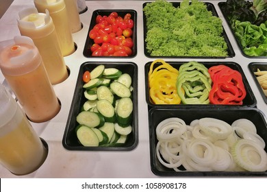 Salads bar with many dressing and a lot of vegetables in the bowl