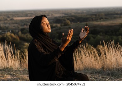 Salah traditional praying to god on the carpet. Black muslim woman praying to Allah