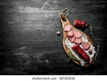 Salami With Fresh Rosemary And Spices. On Black Rustic Background.