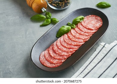 salami sausage on black plate grey background