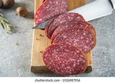 salami slices and knife close up on gray stone background