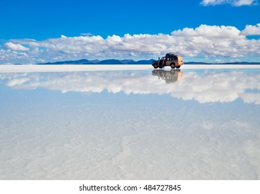 Salar de Uyuni in Bolivien mit Wasser mit Auto- und Wolkenreflektionen weicher Fokus